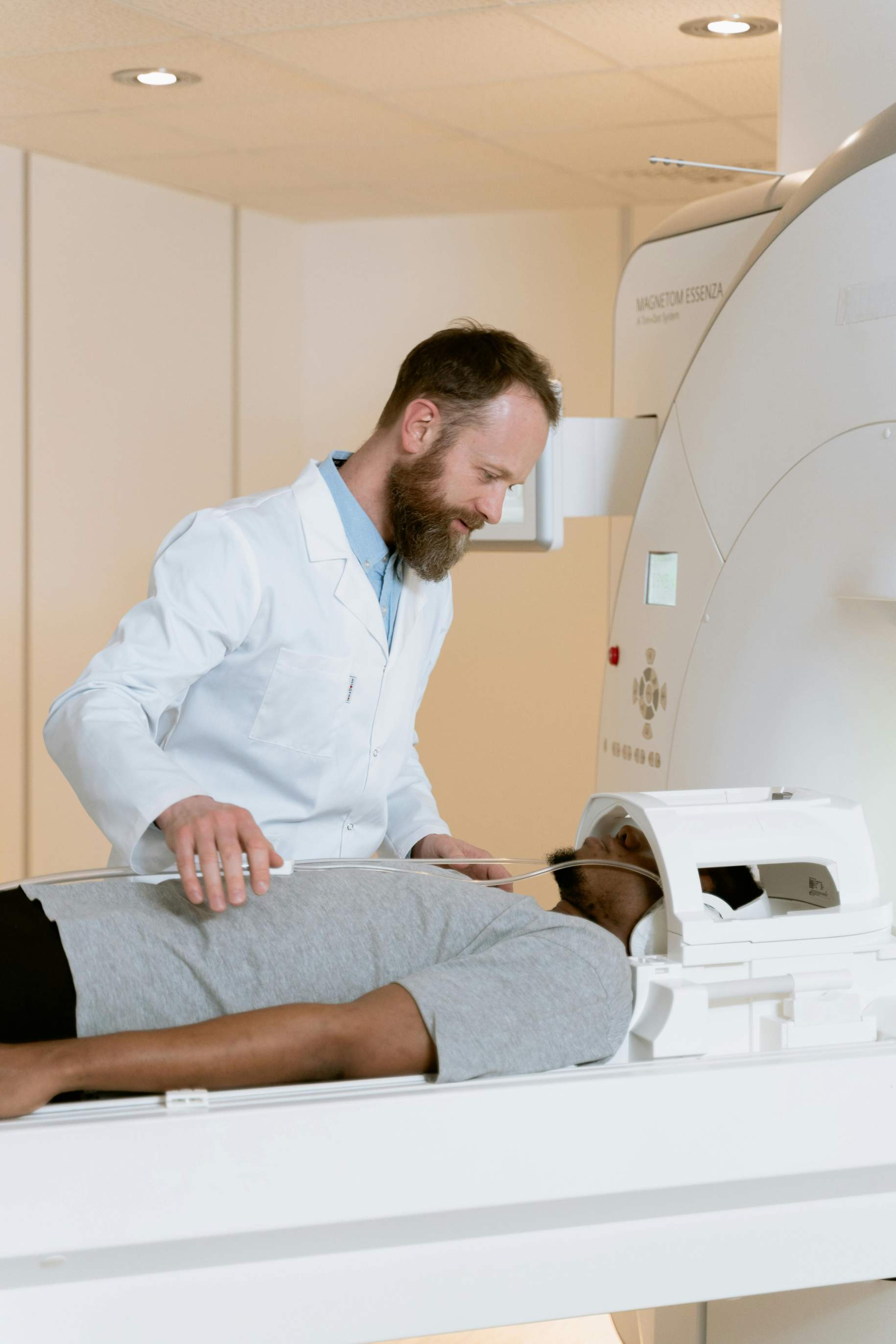Radiologist preparing a patient for an MRI scan, adjusting the position of the patient inside the MRI machine in a medical imaging room.